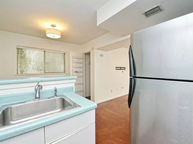 a kitchen with granite countertop white cabinets and a sink