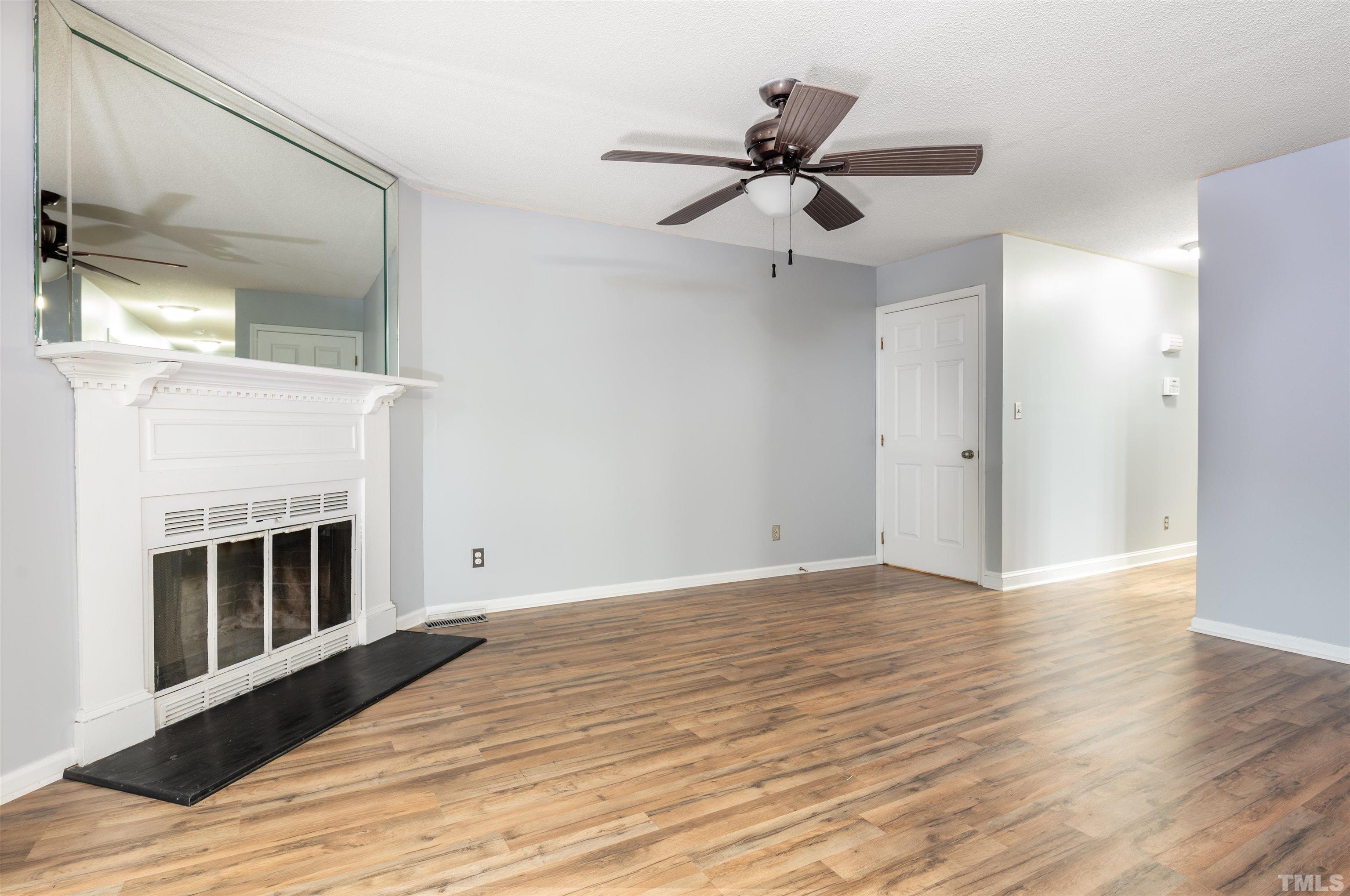 405 Oak Run Drive Raleigh, NC 27606 - Photo 11 of 83 a view of an empty room with wooden floor and a fireplace