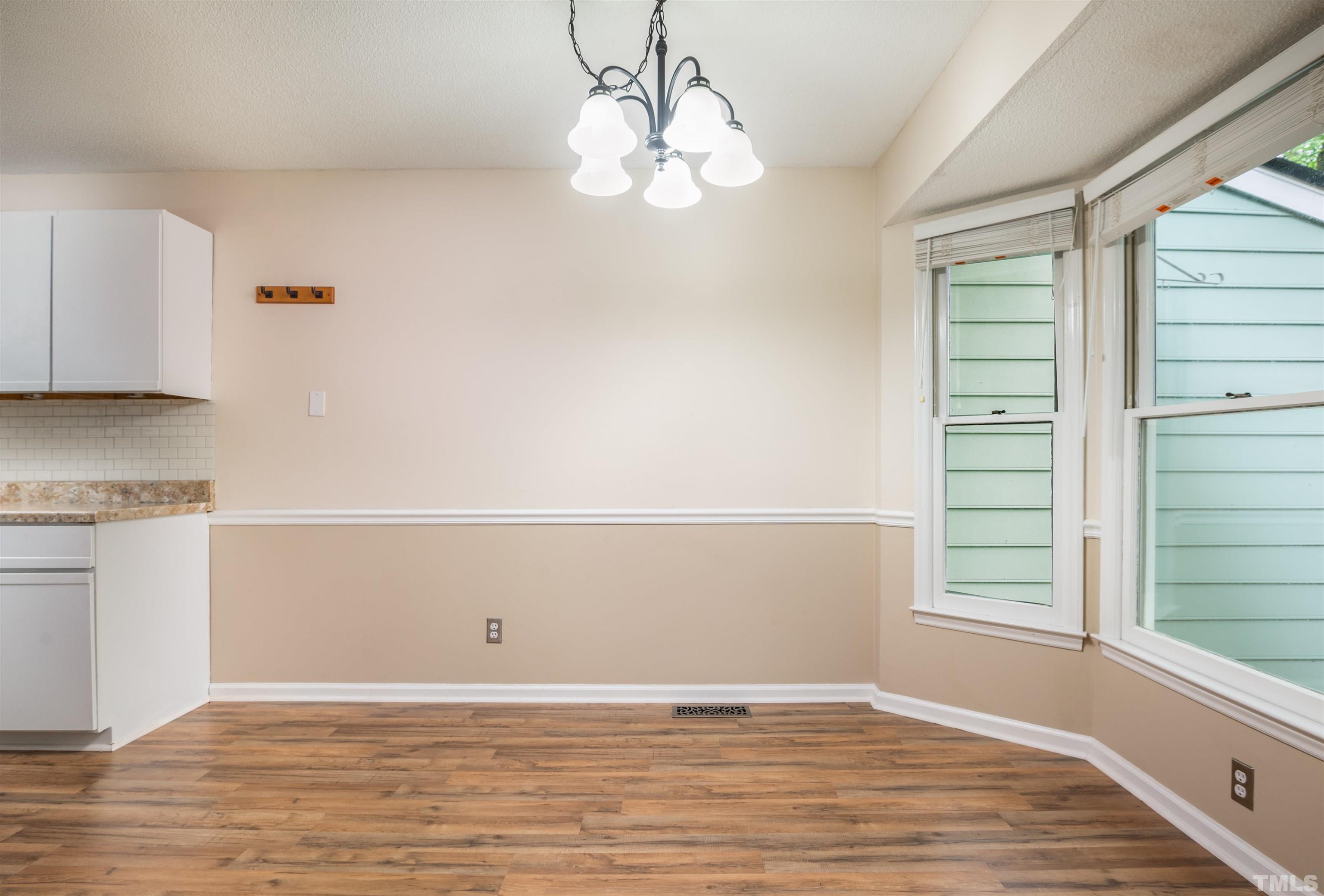 405 Oak Run Drive Raleigh, NC 27606 - Photo 13 of 83 a view of an empty room with wooden floor and a window