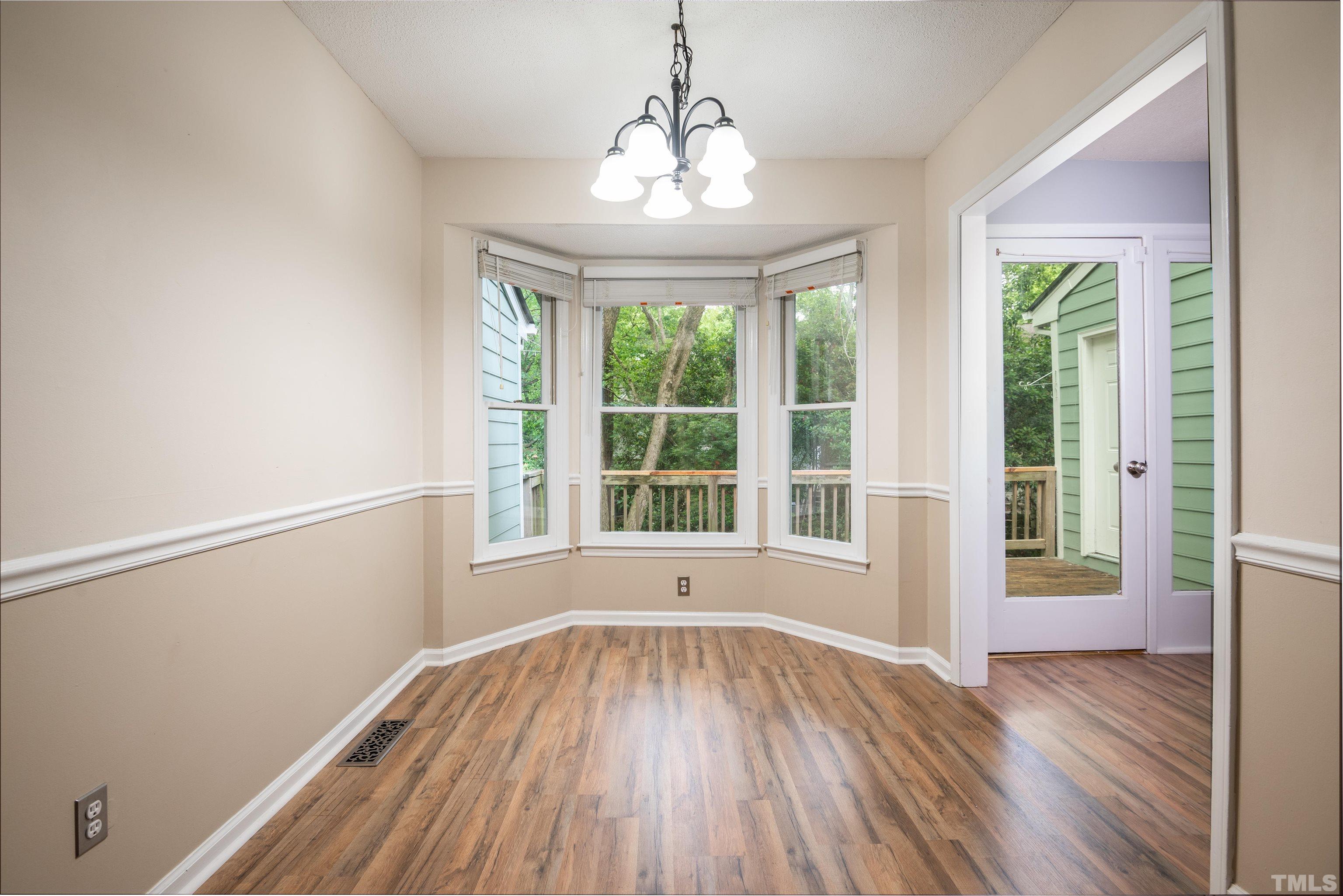 405 Oak Run Drive Raleigh, NC 27606 - Photo 15 of 83 a view of an empty room with wooden floor and a window