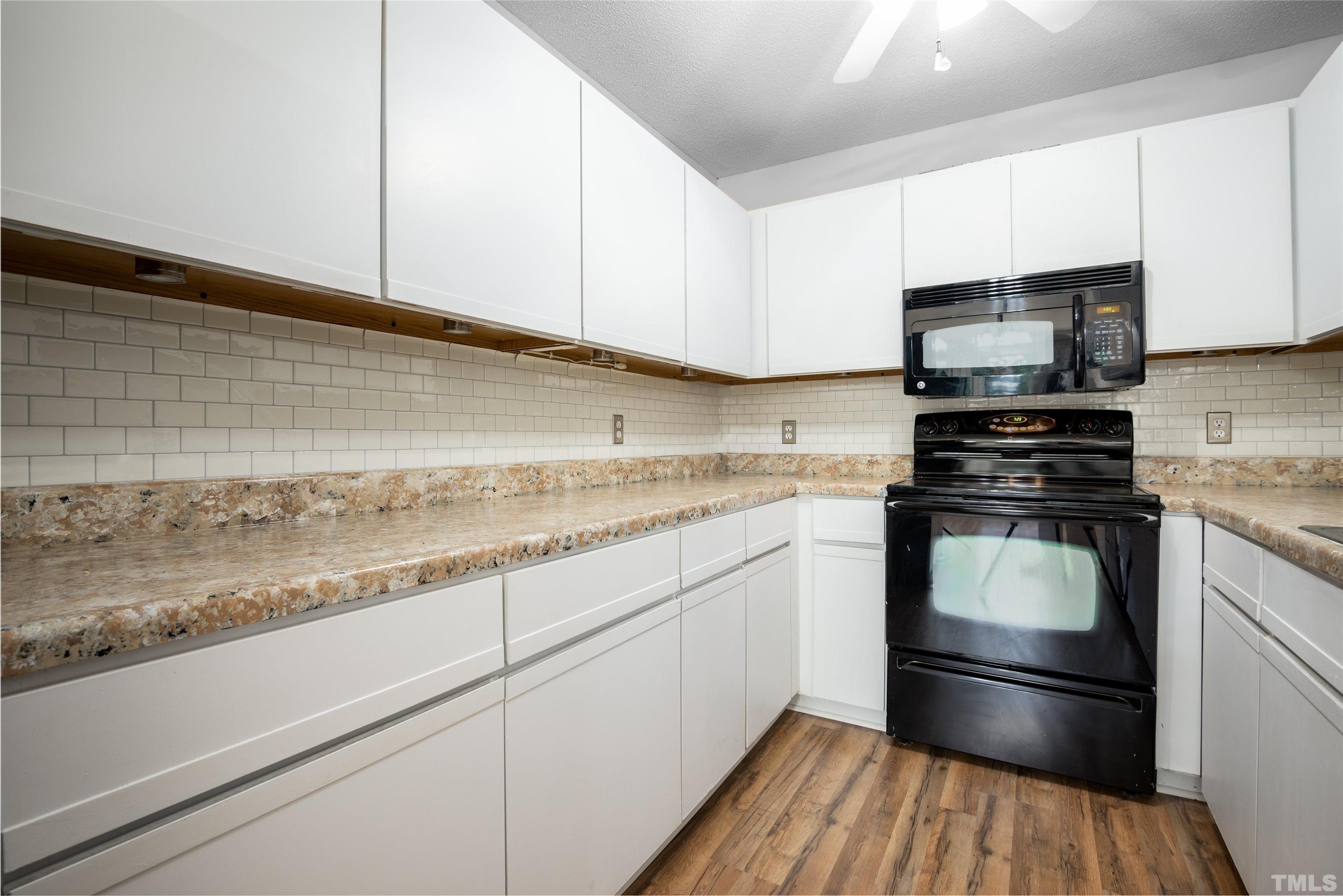 405 Oak Run Drive Raleigh, NC 27606 - Photo 19 of 83 a kitchen with granite countertop white cabinets and stainless steel appliances