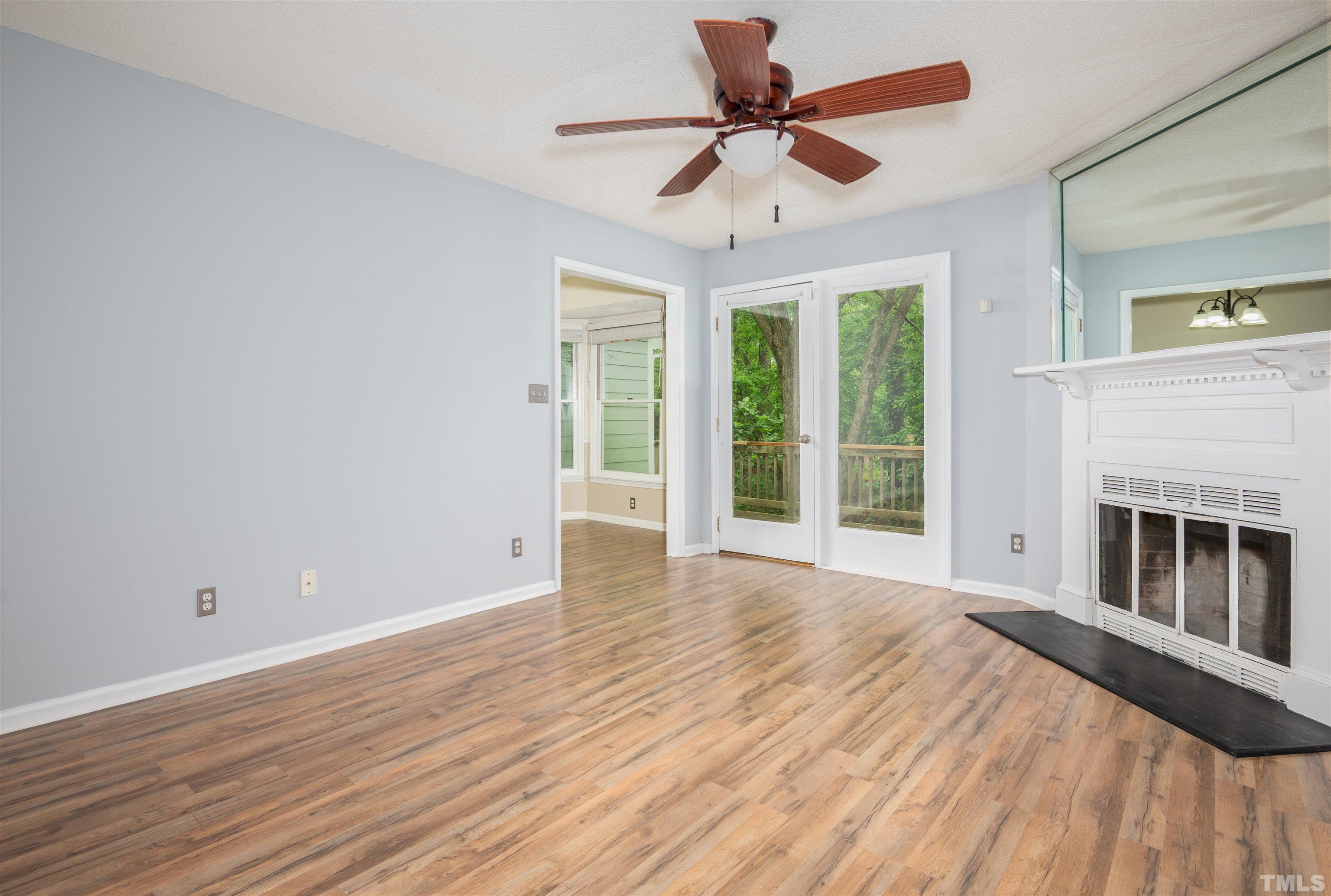405 Oak Run Drive Raleigh, NC 27606 - Photo 7 of 83 a view of an empty room with wooden floor fireplace and a window