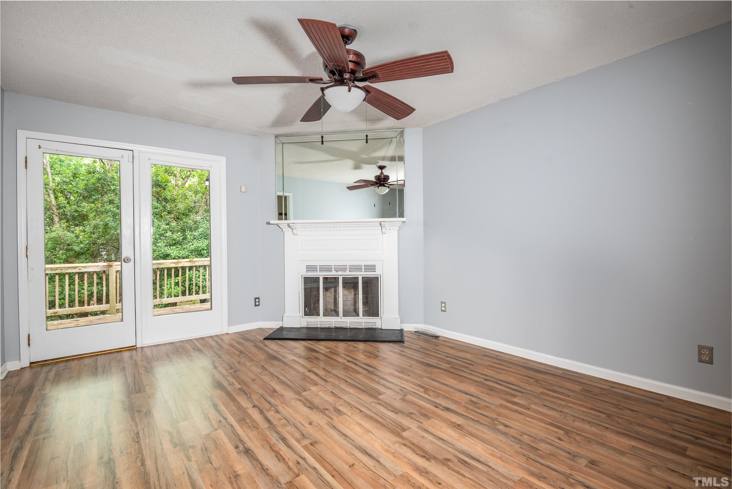 405 Oak Run Drive Raleigh, NC 27606 - Photo 9 of 83 a view of an empty room with wooden floor and a window