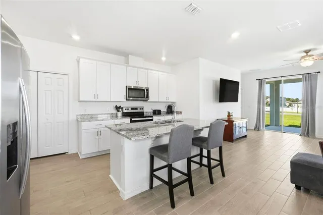 a view of kitchen with microwave stove top oven and cabinets