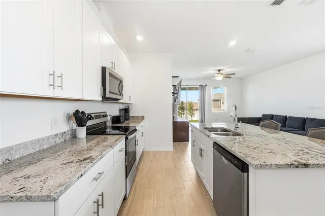 a kitchen with stainless steel appliances granite countertop a sink stove and refrigerator