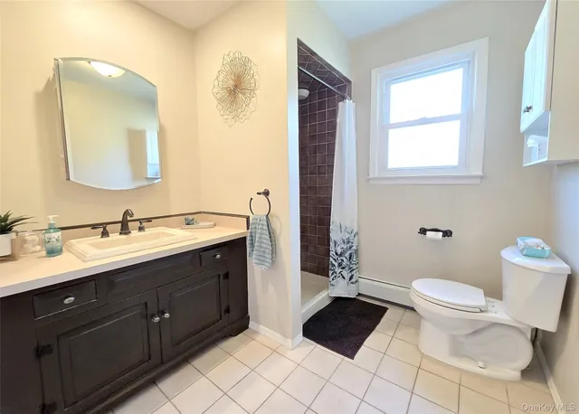 a bathroom with a double vanity sink toilet and mirror