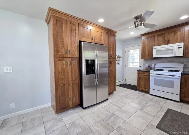 a kitchen with stainless steel appliances granite countertop a refrigerator and a stove top oven