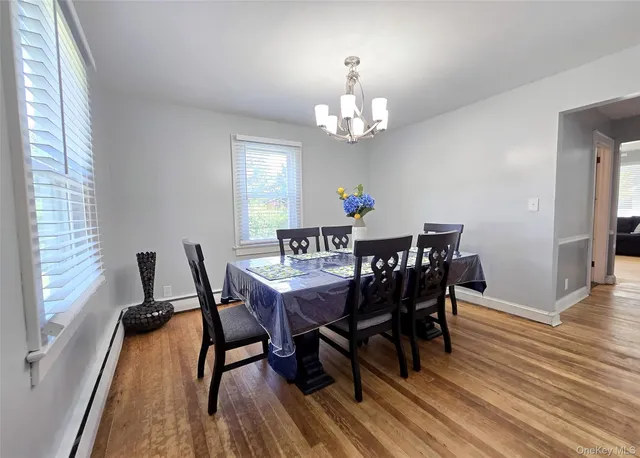 a view of a dining room with furniture a rug and wooden floor