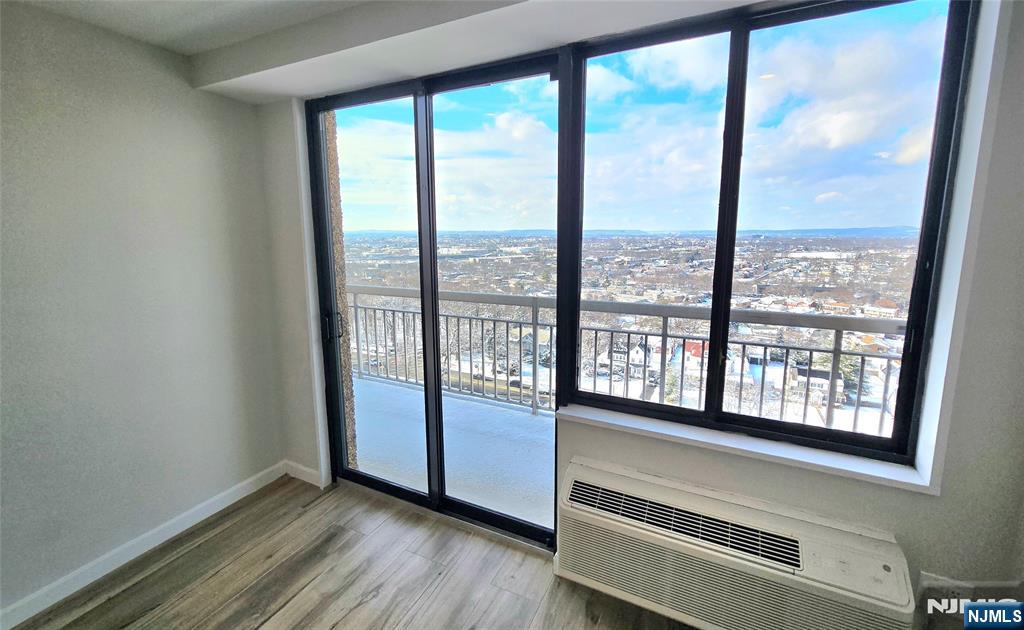 151 Prospect Avenue, Unit 19A Hackensack, NJ 07601 - Photo 12 of 17 a view of an empty room with wooden floor and a window
