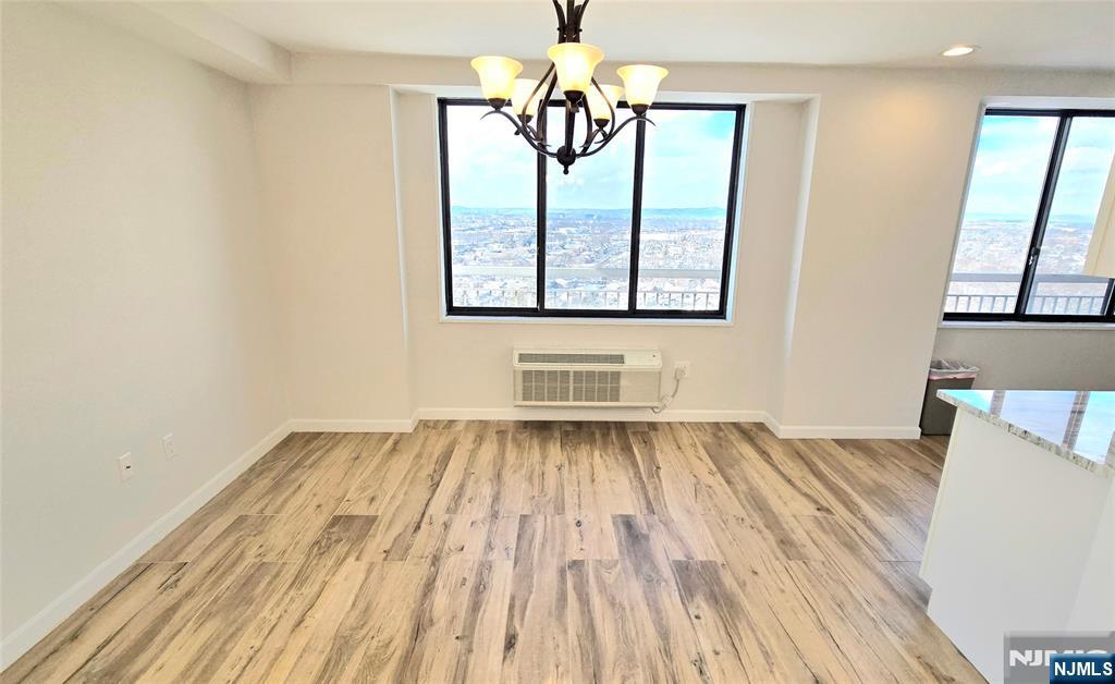 151 Prospect Avenue, Unit 19A Hackensack, NJ 07601 - Photo 8 of 17 a view of an empty room with wooden floor and a window
