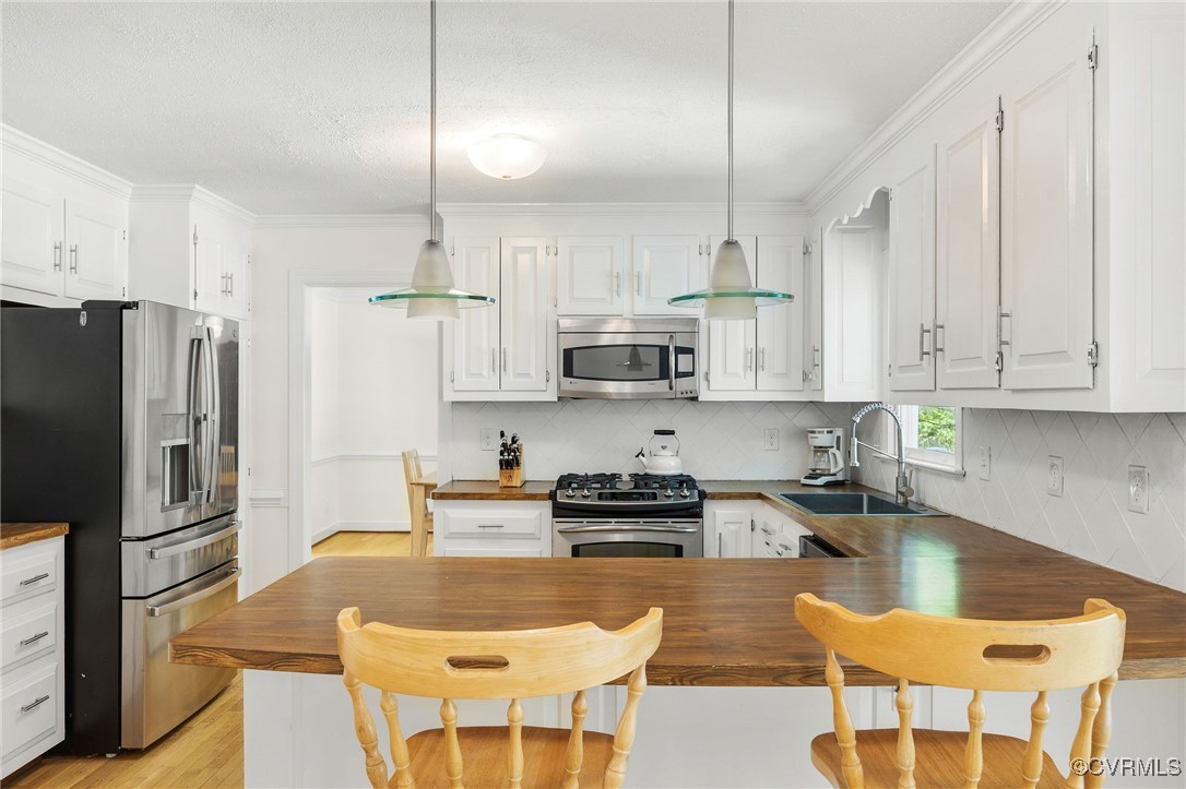 3001 Winterfield Road Midlothian, VA 23113 - Photo 16 of 50 a kitchen with stainless steel appliances granite countertop a sink a stove a refrigerator a microwave and white cabinets