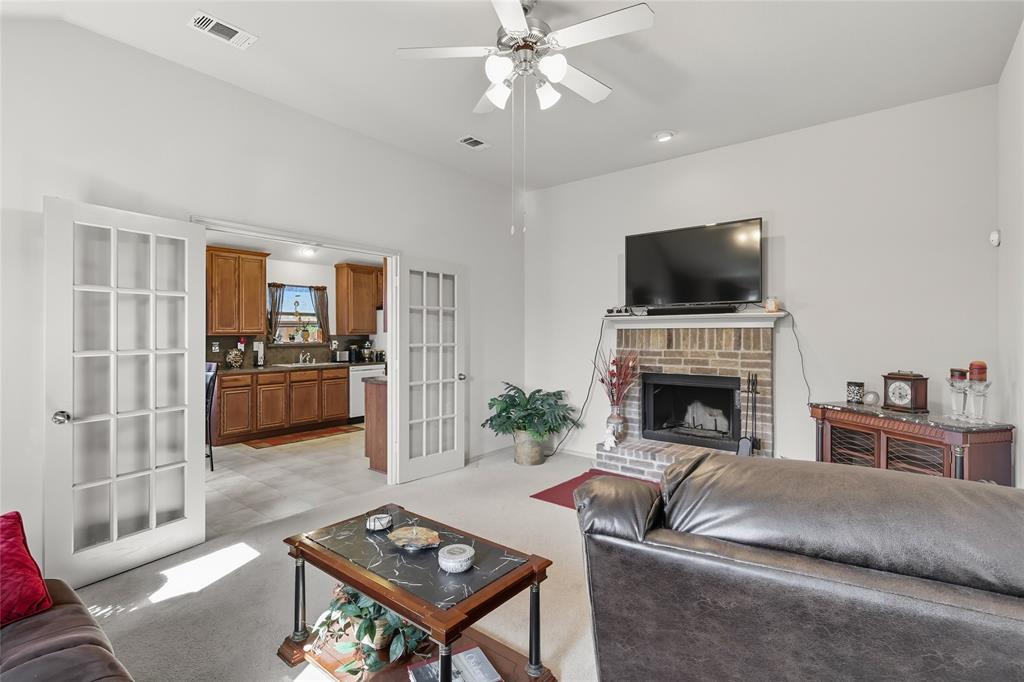 2708 Stockton Street Denton, TX 76209 - Photo 17 of 40 a living room with furniture a fireplace and a flat screen tv
