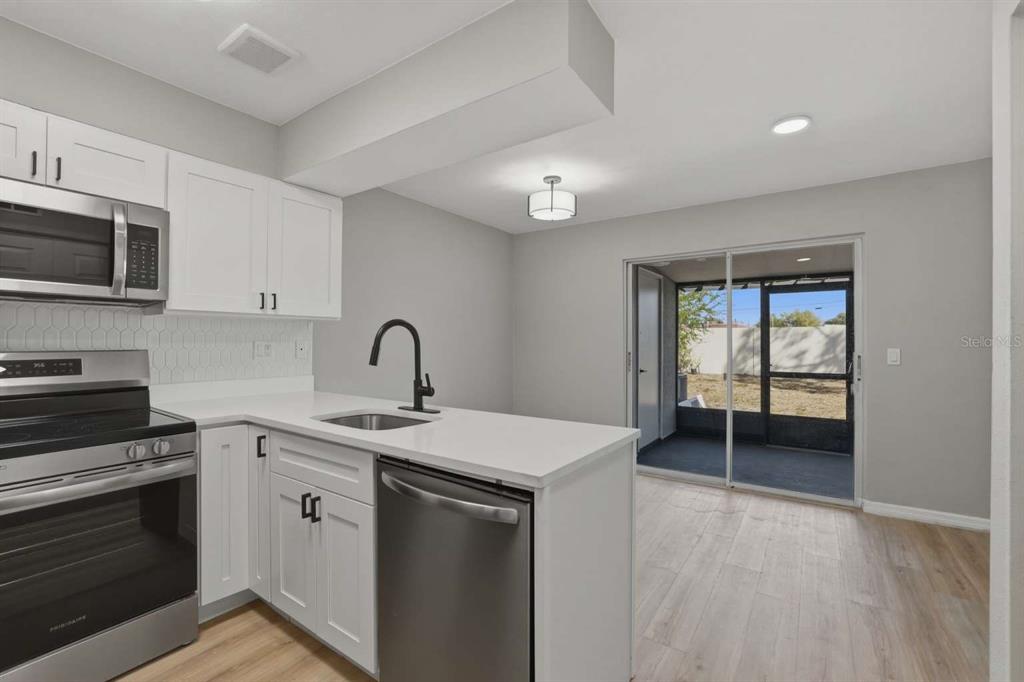 6600 121st Avenue, Unit 3 Largo, FL 33773 - Photo 7 of 27 a kitchen with a sink and a stove top oven