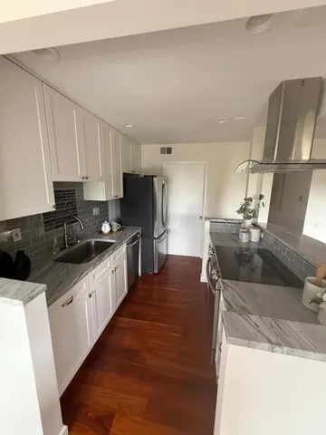 a kitchen with stainless steel appliances granite countertop a sink stove and refrigerator