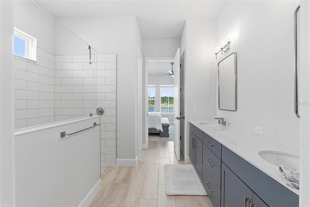 270 Azure Mist Way Daytona Beach, FL 32124 - Photo 31 of 71 a spacious bathroom with a double vanity sink a large mirror and shower