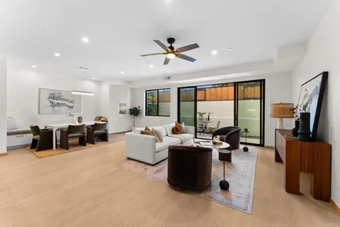 a bedroom with a bed a large window and a chandelier
