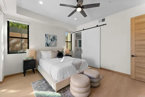 a spacious bedroom with a bed and glass window