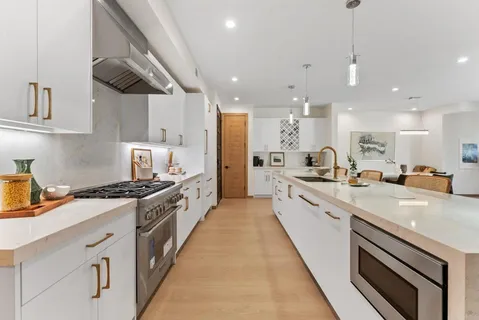 a large kitchen with stainless steel appliances granite countertop a large stove a sink and a refrigerator