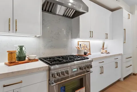 a kitchen with white cabinets and a stove