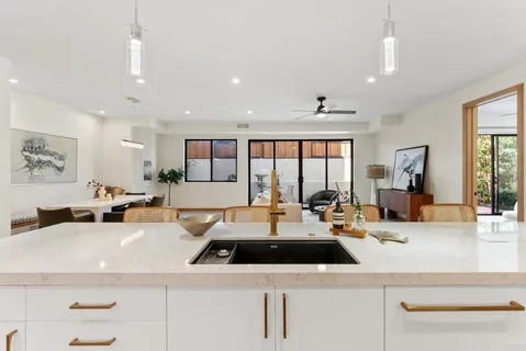 a kitchen with stainless steel appliances kitchen island a table and chairs in it