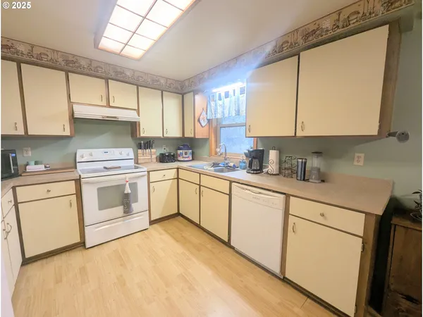 a kitchen with refrigerator cabinets and wooden floor