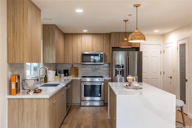 a kitchen with kitchen island a sink stainless steel appliances and cabinets