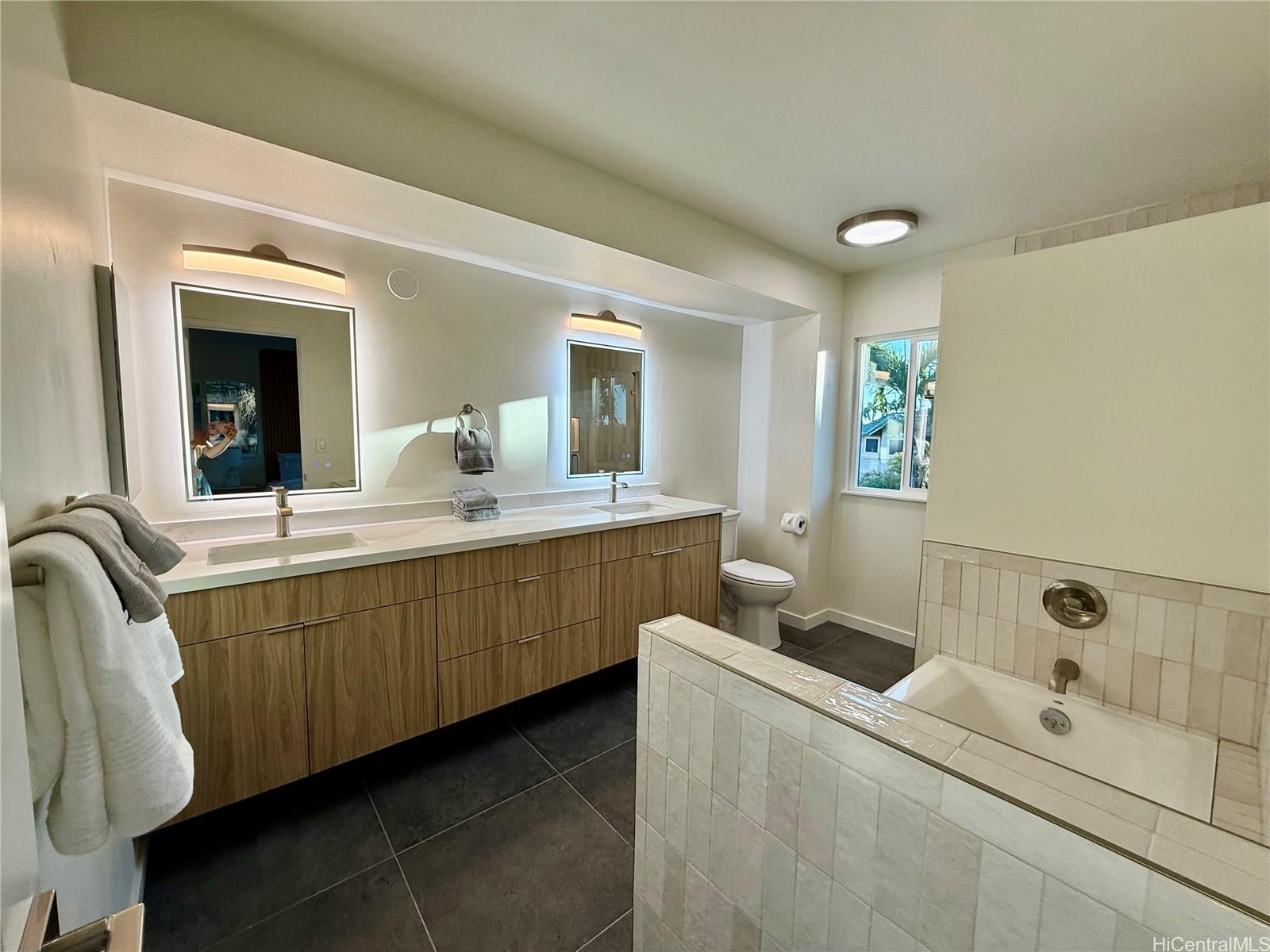 92-1274 Palahia Street Kapolei, HI 96707 - Photo 6 of 11 a bathroom with a double vanity sink a mirror and a bathtub