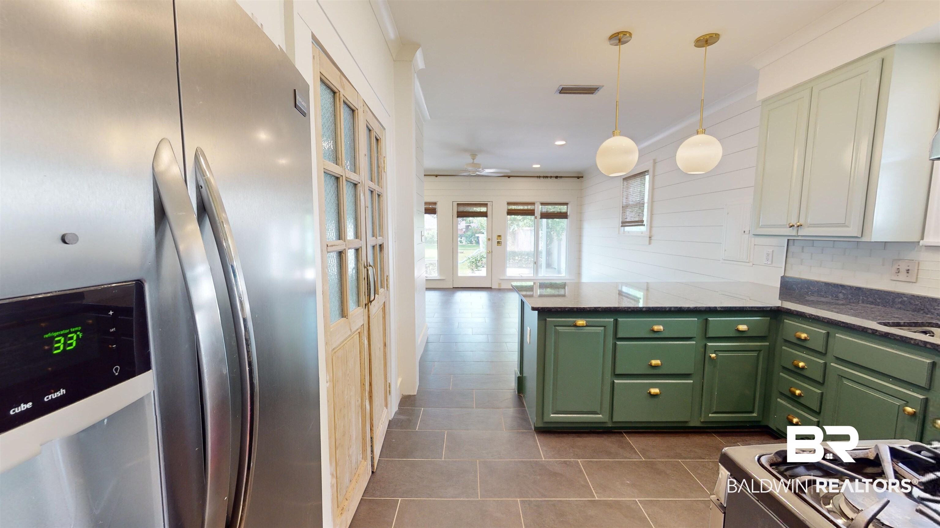 4307 Stein Street Mobile, AL 36608 - Photo 7 of 28 Kitchen with dark tile patterned floors, tasteful backsplash, ceiling fan, pendant lighting, and stainless steel fridge