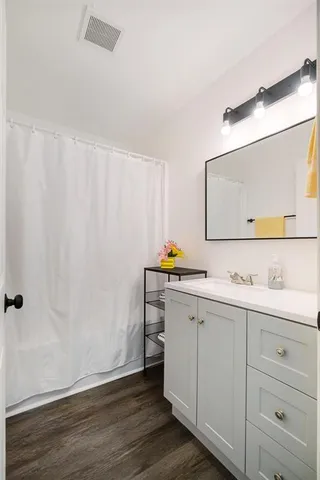 a bathroom with a granite countertop sink and a mirror