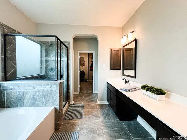 a bathroom with a tub sink and mirror