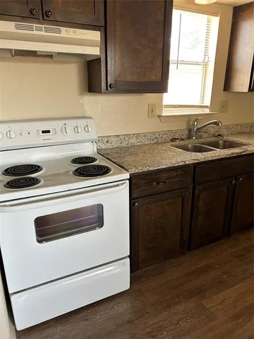 a kitchen with a stove and white cabinets