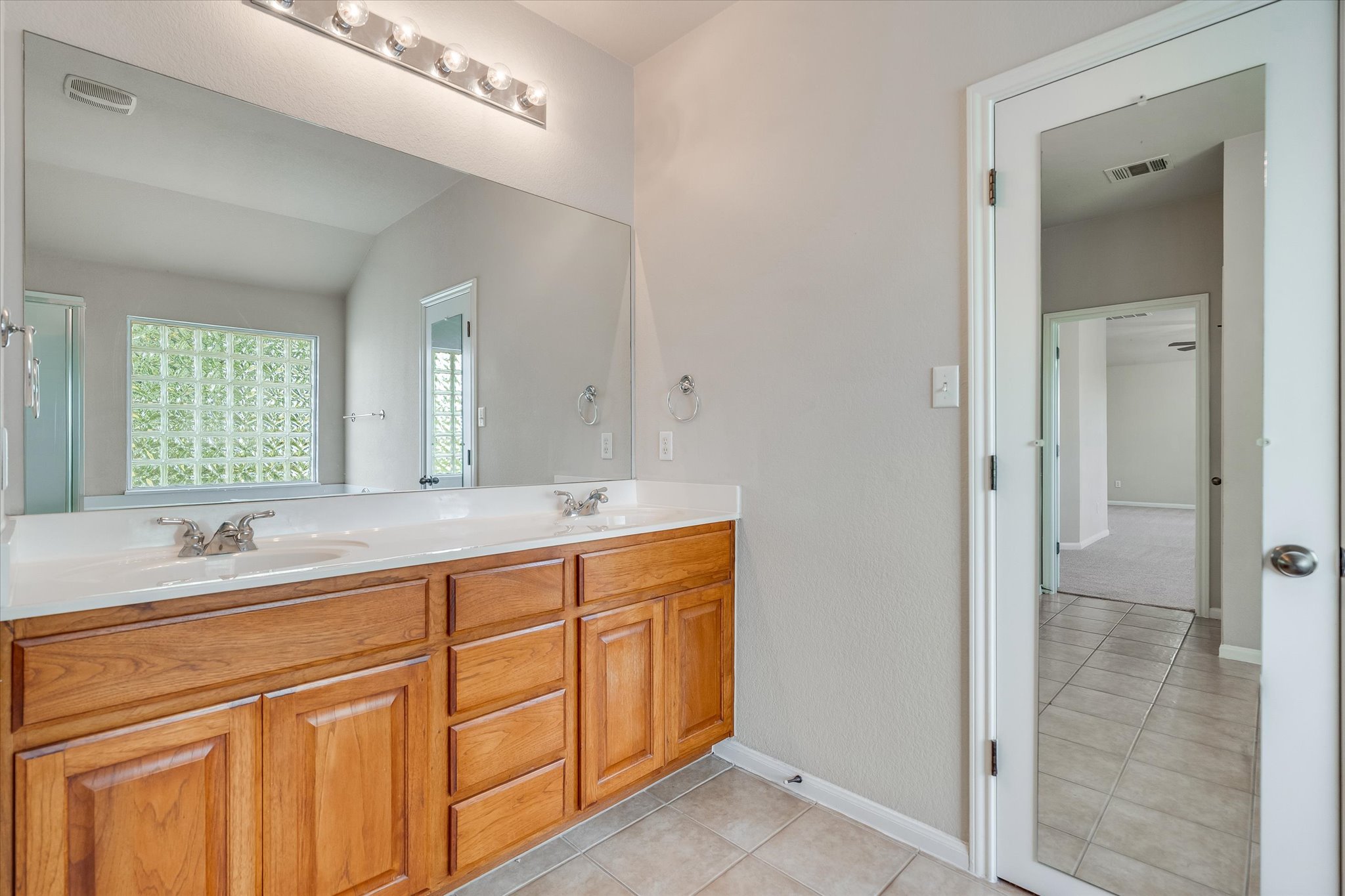 4029 Lake Edge Way Pflugerville, TX 78660 - Photo 14 of 35 Bathroom with double vanity and light tile patterned floors