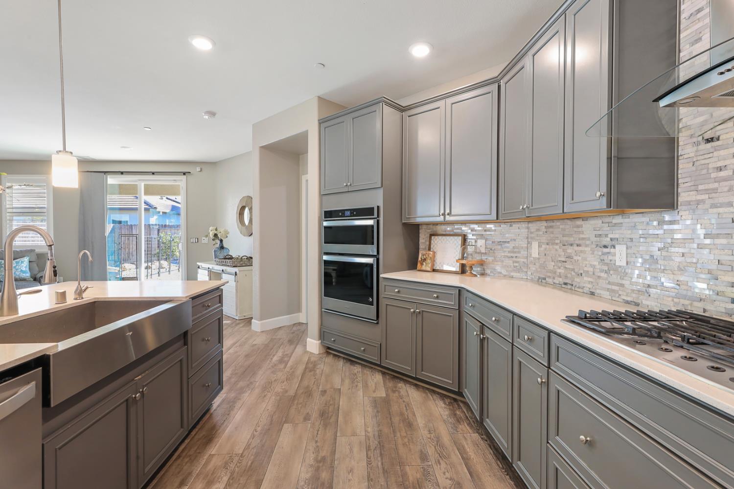 1676 Red Ribbons Lane Manteca, CA 95337 - Photo 16 of 33 a kitchen with kitchen island granite countertop a sink stove and refrigerator