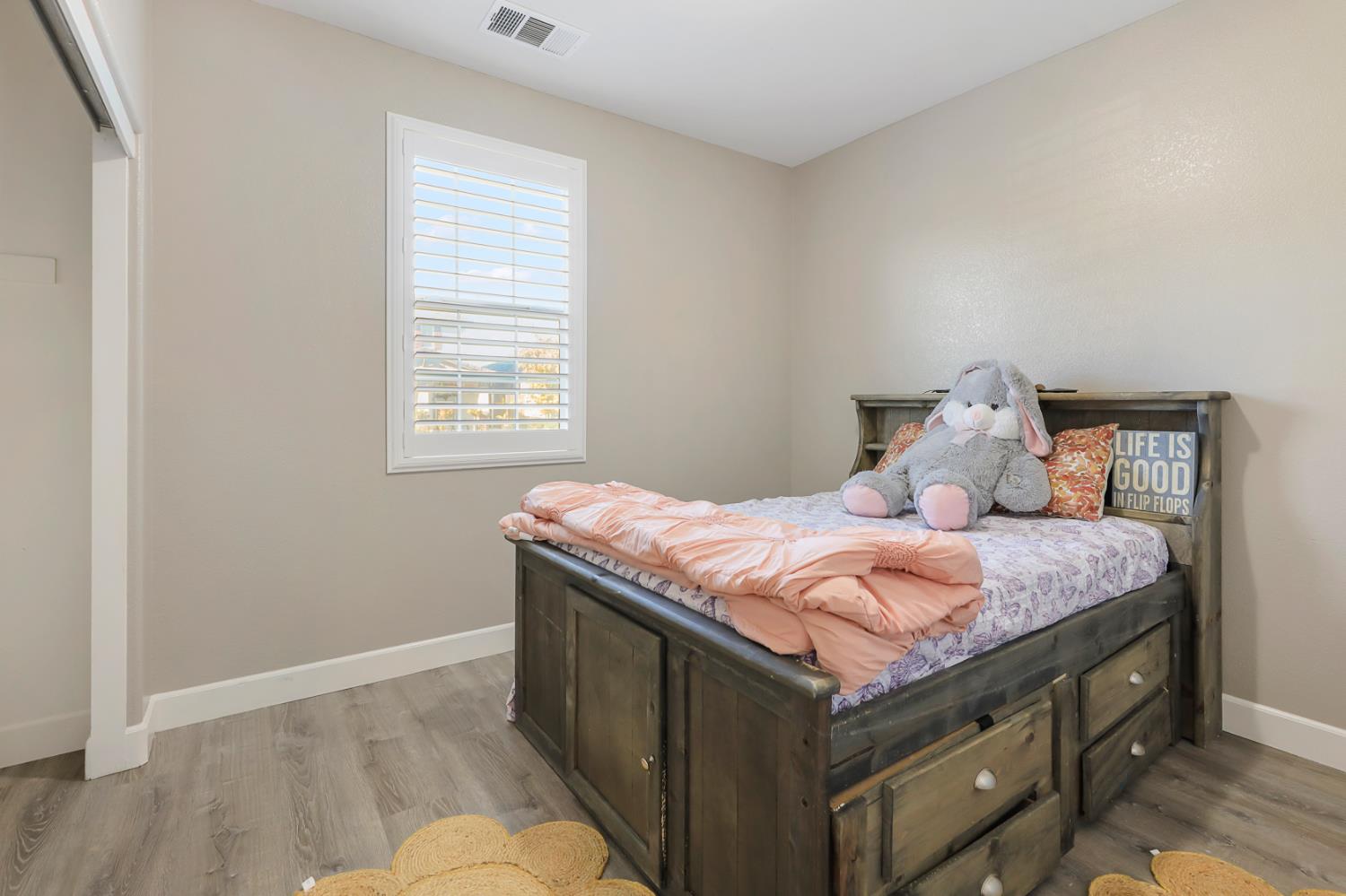 1676 Red Ribbons Lane Manteca, CA 95337 - Photo 33 of 33 a bedroom with a bed and wooden floor