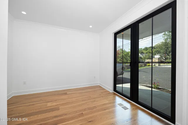 a view of empty room with wooden floor and floor to ceiling window