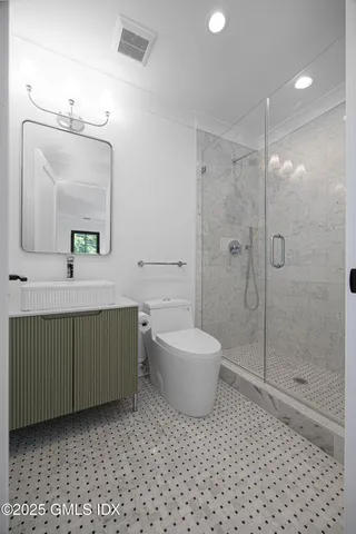 a bathroom with a double vanity sink mirror and toilet