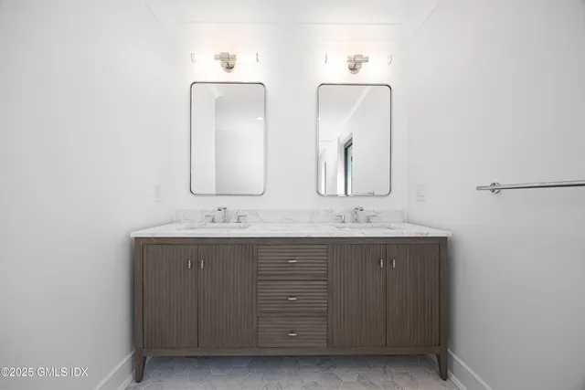 a bathroom with double vanity sinks and a mirror