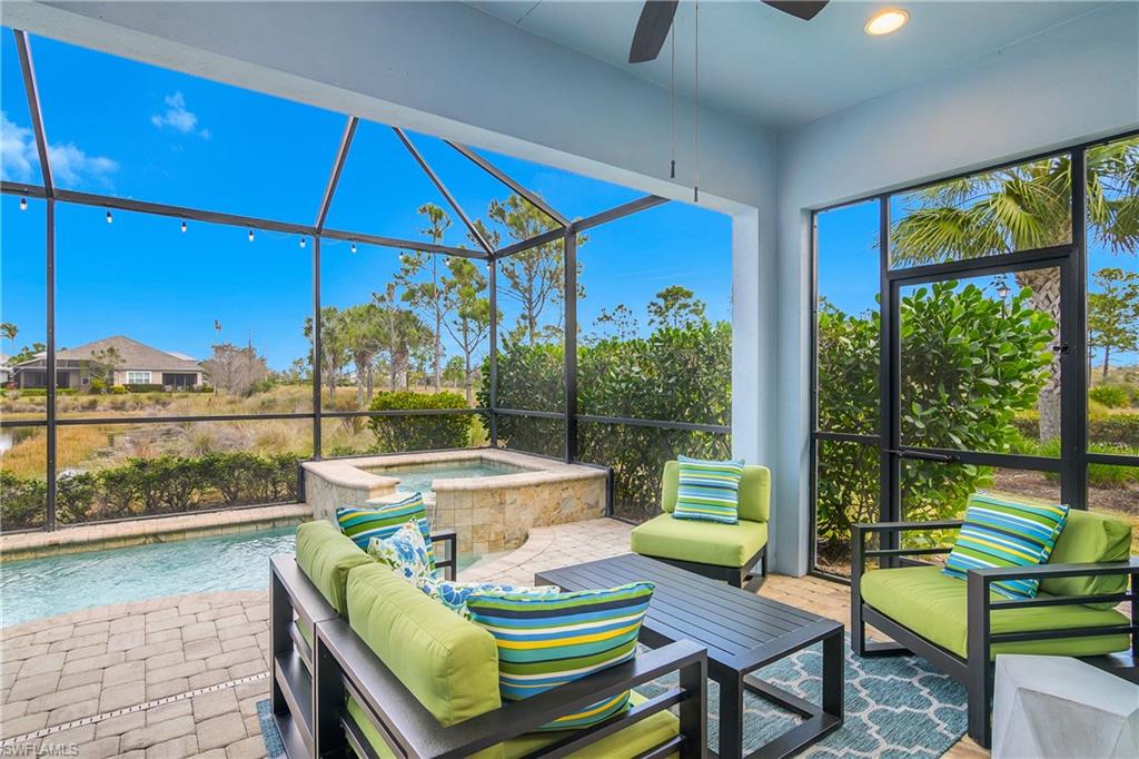 6907 Cay Court Naples, FL 34113 - Photo 14 of 50 Screened Lanai with outdoor seating, a ceiling fan and great water views.