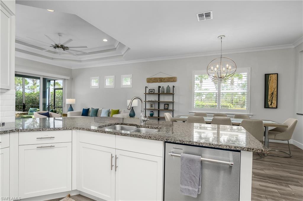 6907 Cay Court Naples, FL 34113 - Photo 50 of 50 Kitchen with dishwasher, white cabinets, open floor plan, stone countertops, and ornamental molding