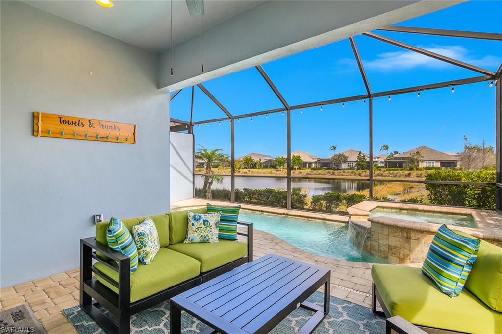 6907 Cay Court Naples, FL 34113 - Photo 30 of 50 View of patio / terrace featuring a sunroom, glass enclosure, a residential view, a pool with connected hot tub, and a water view