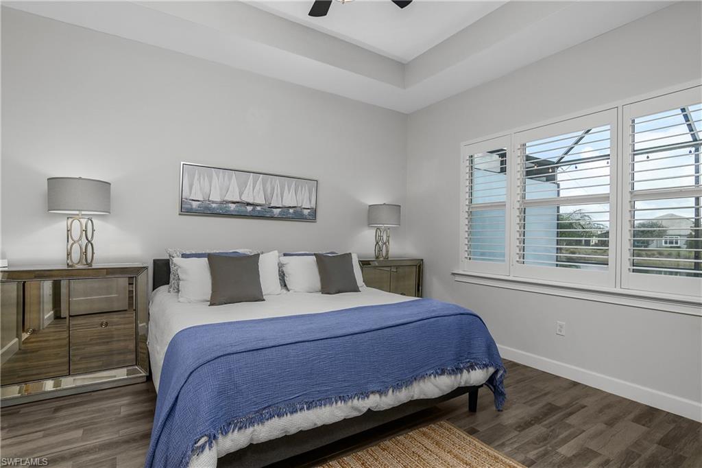 6907 Cay Court Naples, FL 34113 - Photo 7 of 50 Owner's Suite featuring Tile Plank-wood-style flooring and ceiling fan. Plantation Shutters.