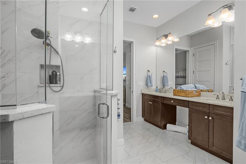 6907 Cay Court Naples, FL 34113 - Photo 8 of 50 Owner's Bathroom with double vanity, a marble finish shower, light marble finish floors, and recessed lighting