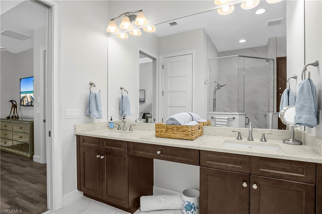 6907 Cay Court Naples, FL 34113 - Photo 9 of 50 Owner's bath featuring double vanity and a marble finish shower