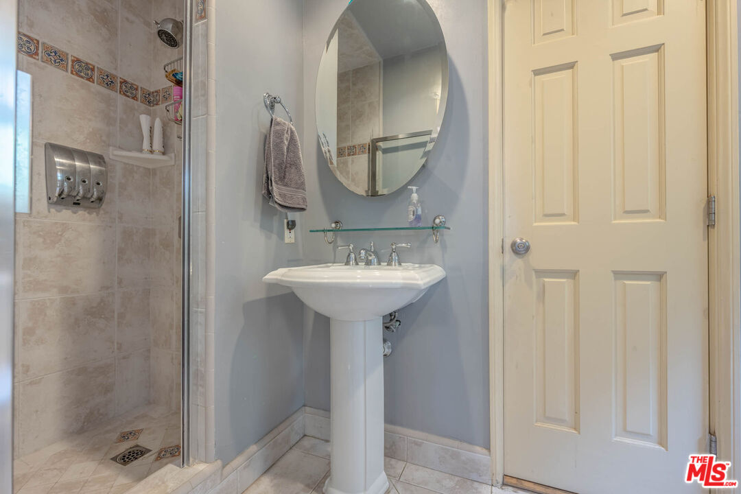 9038 Cresta Drive Los Angeles, CA 90035 - Photo 11 of 23 a bathroom with a sink a mirror a shower and vanity