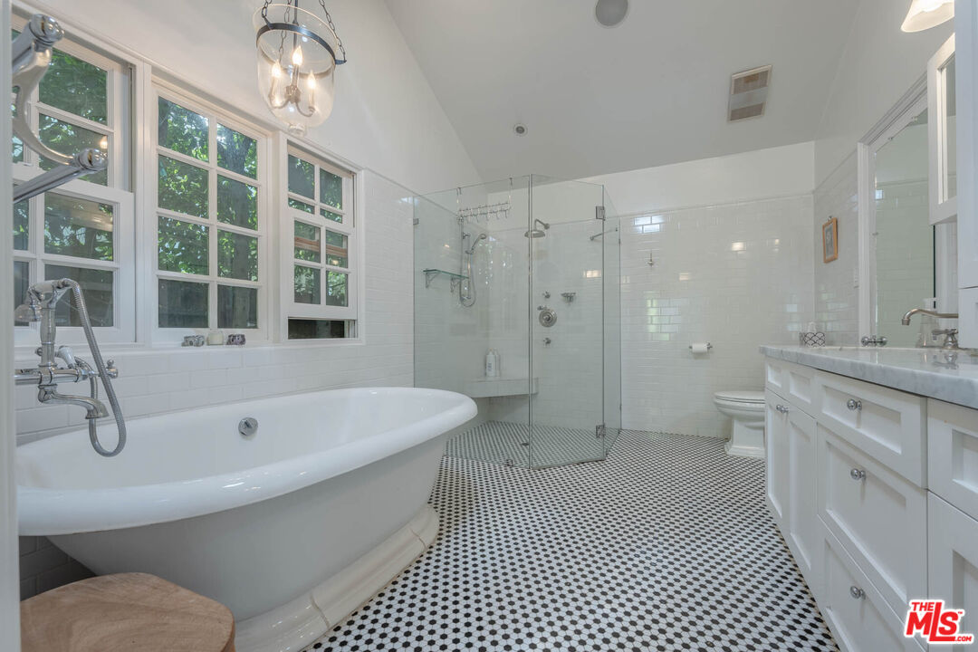 9038 Cresta Drive Los Angeles, CA 90035 - Photo 13 of 23 a bathroom with a granite countertop sink a toilet a mirror and shower
