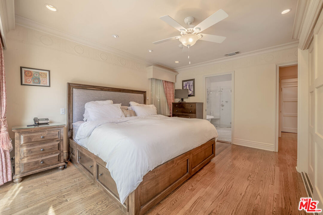 9038 Cresta Drive Los Angeles, CA 90035 - Photo 15 of 23 a bedroom with a large bed and a chandelier