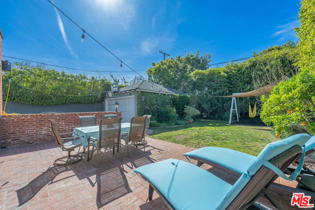 9038 Cresta Drive Los Angeles, CA 90035 - Photo 21 of 23 a view of a patio with table and chairs under an umbrella