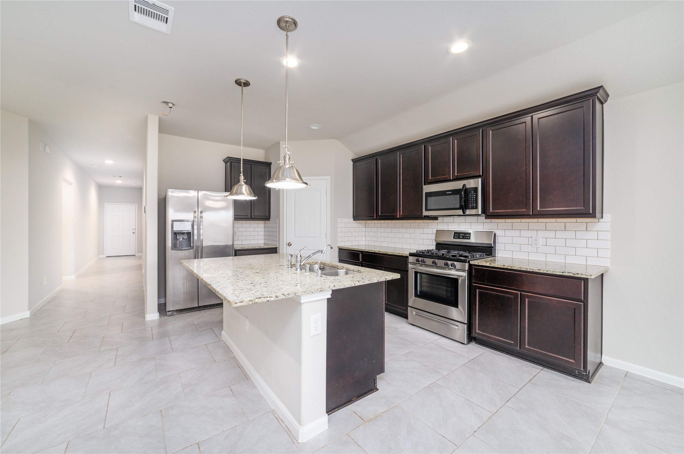 8307 Oakleaf Meadow Court Rosharon, TX 77583 - Photo 11 of 39 a kitchen with stainless steel appliances a stove sink microwave and refrigerator