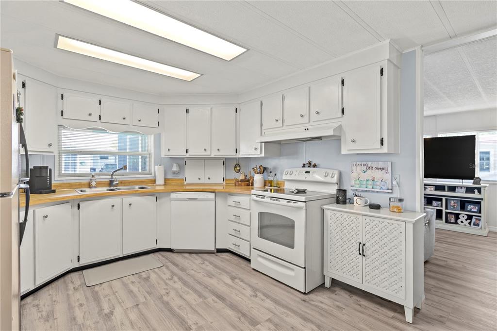 5619 Bayshore Road, Unit 240 Palmetto, FL 34221 - Photo 6 of 33 a kitchen with white cabinets sink and stainless steel appliances