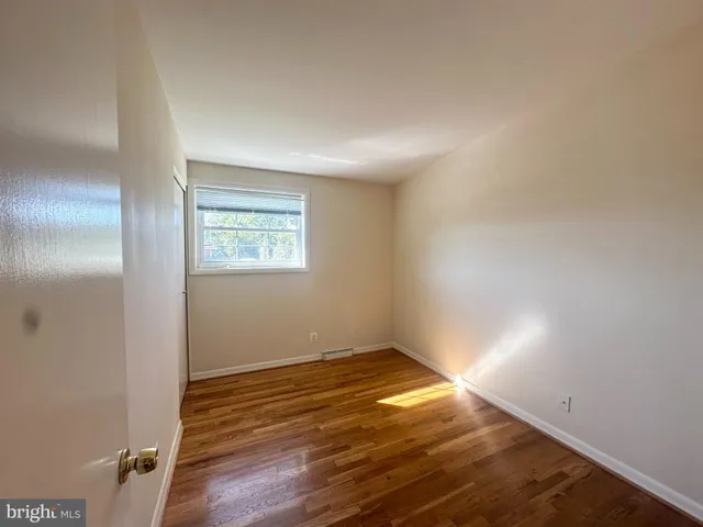 a view of a room with wooden floor and a ceiling fan